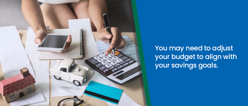 You may need to adjust your budget to align with your savings goals - Woman working with a calculator